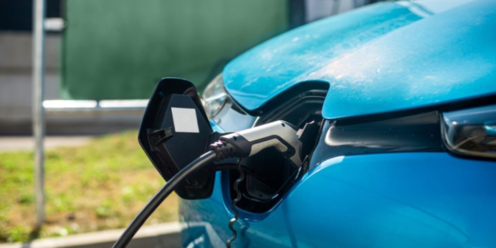 Fotografia colorida mostra um carro elétrico carregando