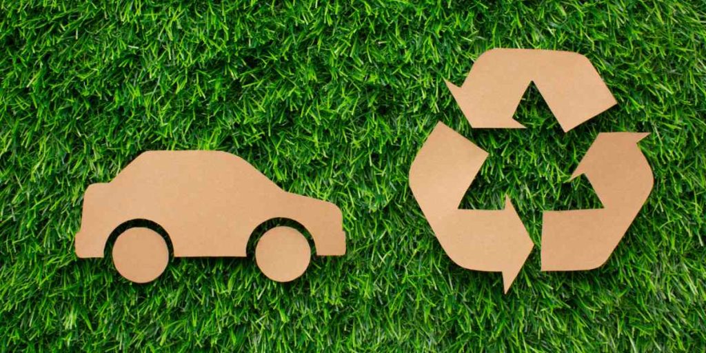 Foto de carro e simbolo de reciclagem representando mobilidade sustentável.