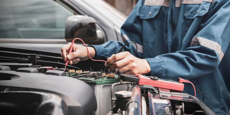 Foto de pessoa fazendo manutenção de carro elétrico.