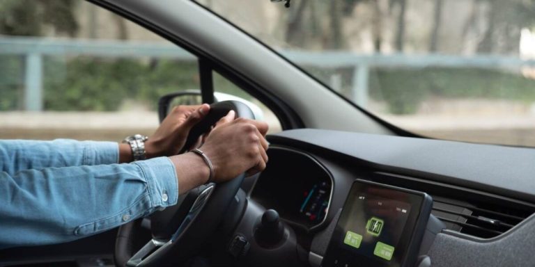 Foto de pessoa dirigindo carro elétrico.