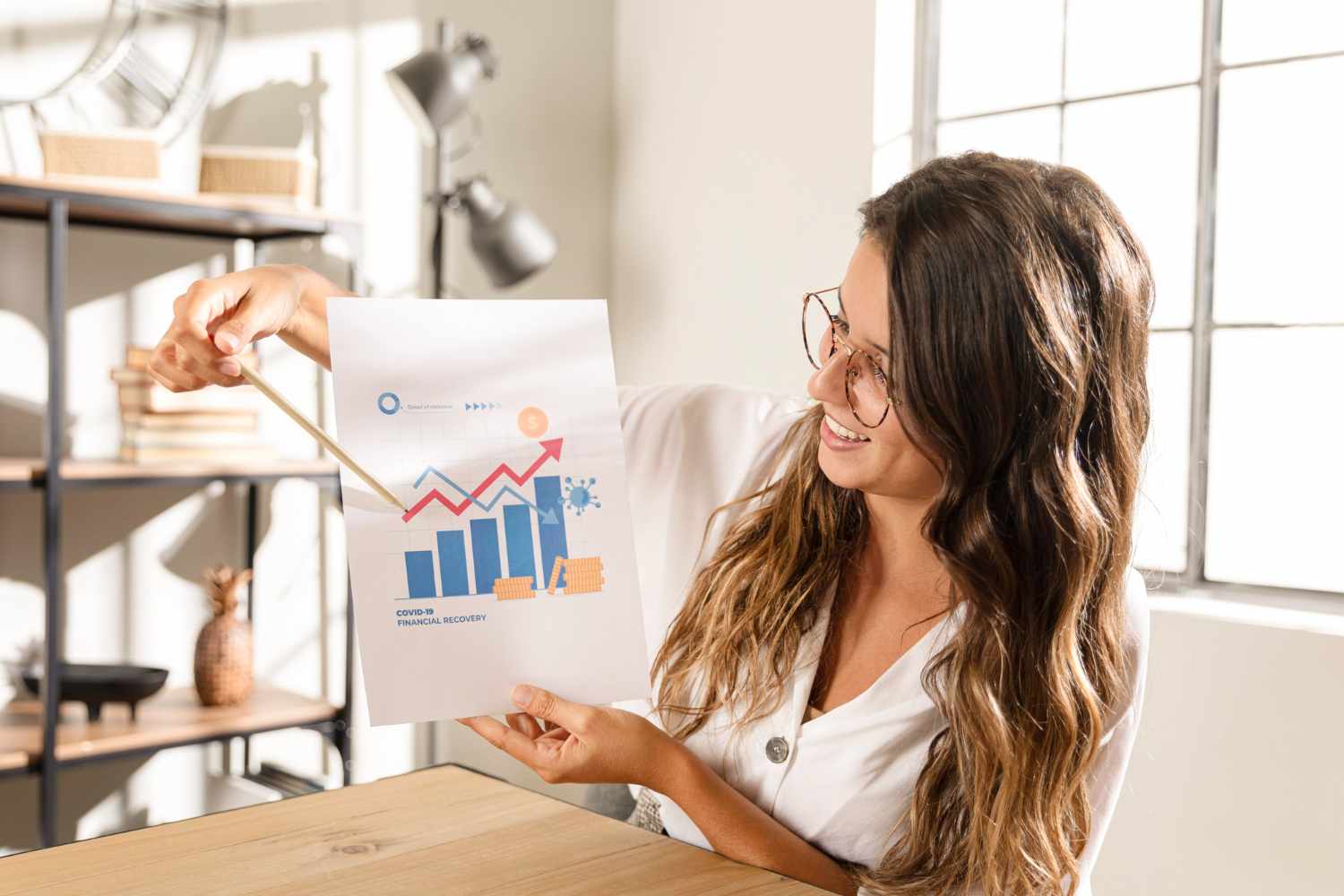 Mulher de óculos apresentando um gráfico com dados de crescimento em um ambiente de escritório, simbolizando análise de dados e progresso empresarial.