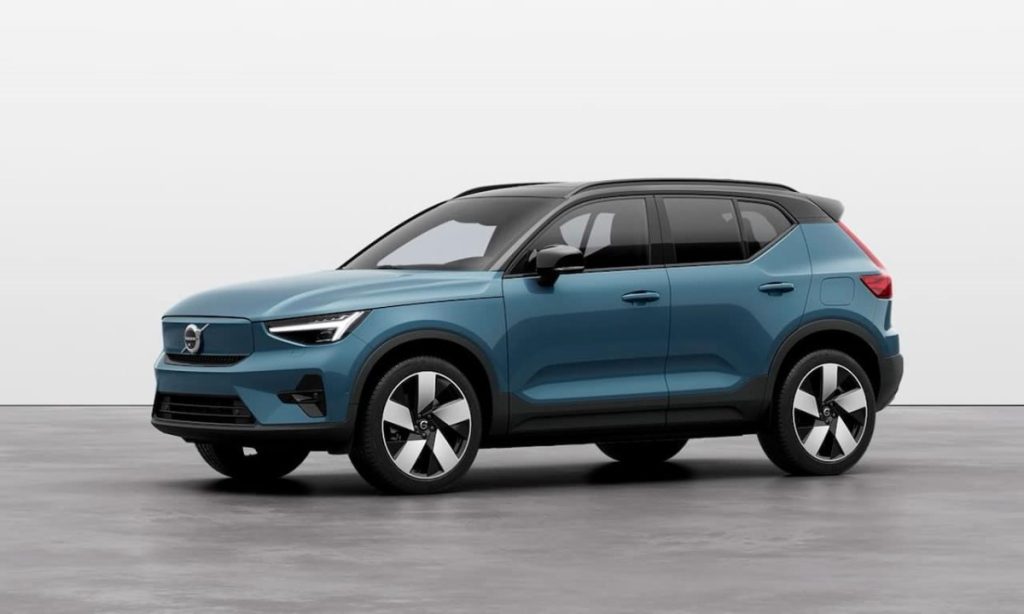 Imagem de um Volvo XC40, SUV compacto, na cor azul escuro com teto preto, estacionado em um fundo cinza claro.