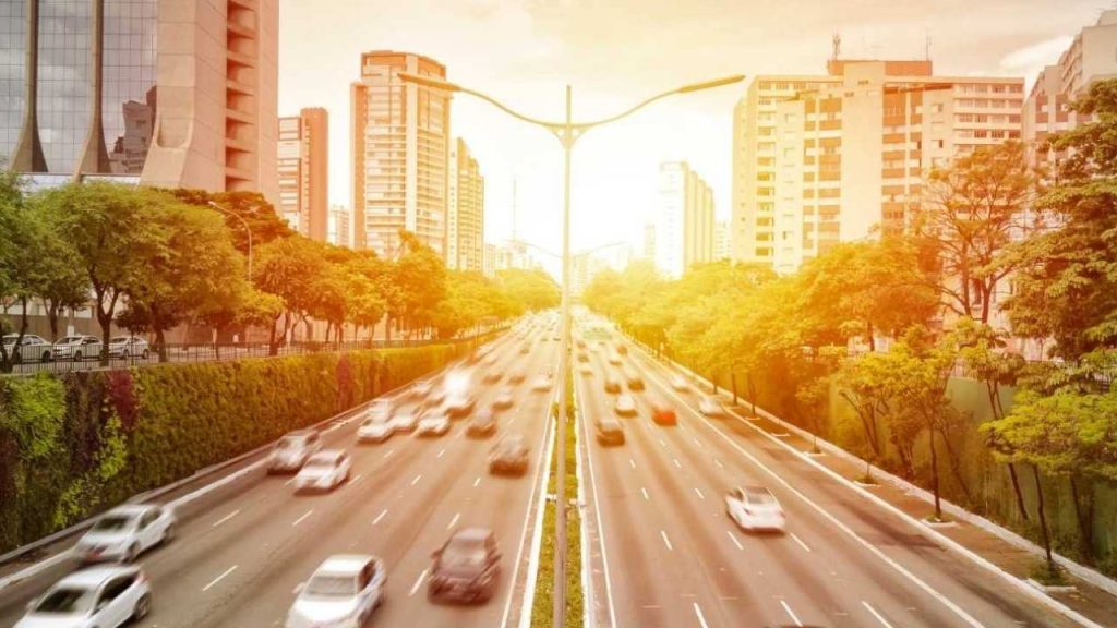 tráfego intenso em uma avenida principal de São Paulo ao pôr do sol.