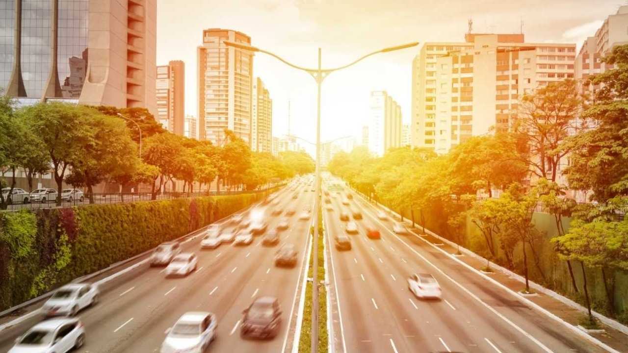 tráfego intenso em uma avenida principal de São Paulo ao pôr do sol.