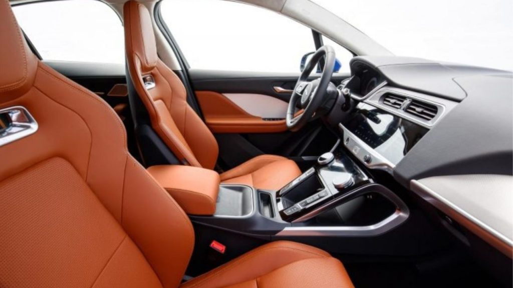  interior do Jaguar I-PACE com bancos em couro laranja e painel sofisticado.