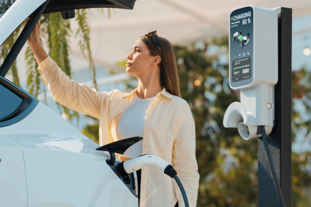 mulher fazendo carregamento de carro elétrico em eletroposto.